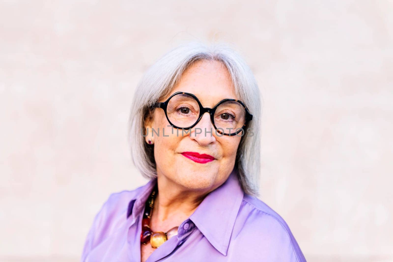 portrait of nice senior woman in glasses smiling looking at camera, concept of happiness of elderly people and active lifestyle, copy space for text