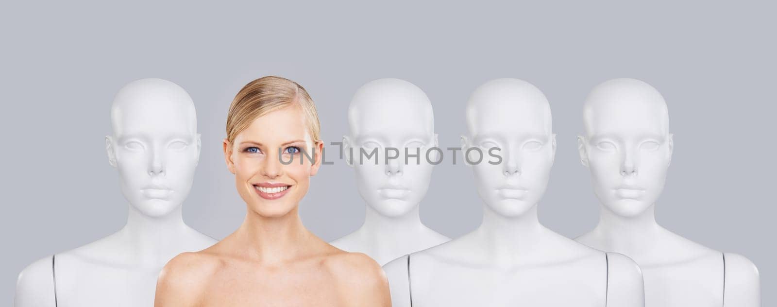 Woman, mannequins and smile for identity, beauty and individuality on studio background. Person, skincare and dummy with face for creativity and cosmetics or unique ideas for satisfaction and skin by YuriArcurs