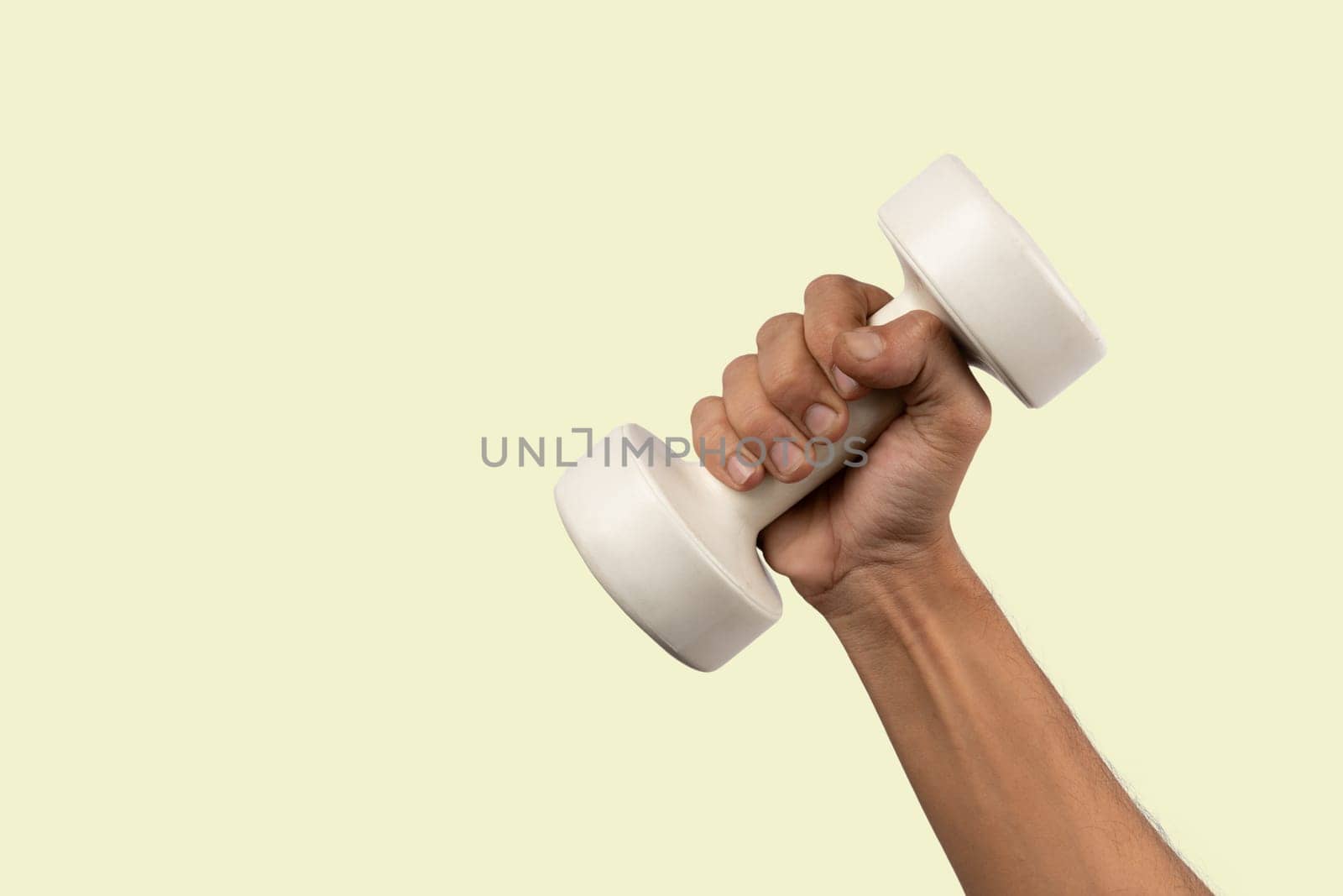 Black male hand holding a white dumbell isolated, light green background. High quality photo