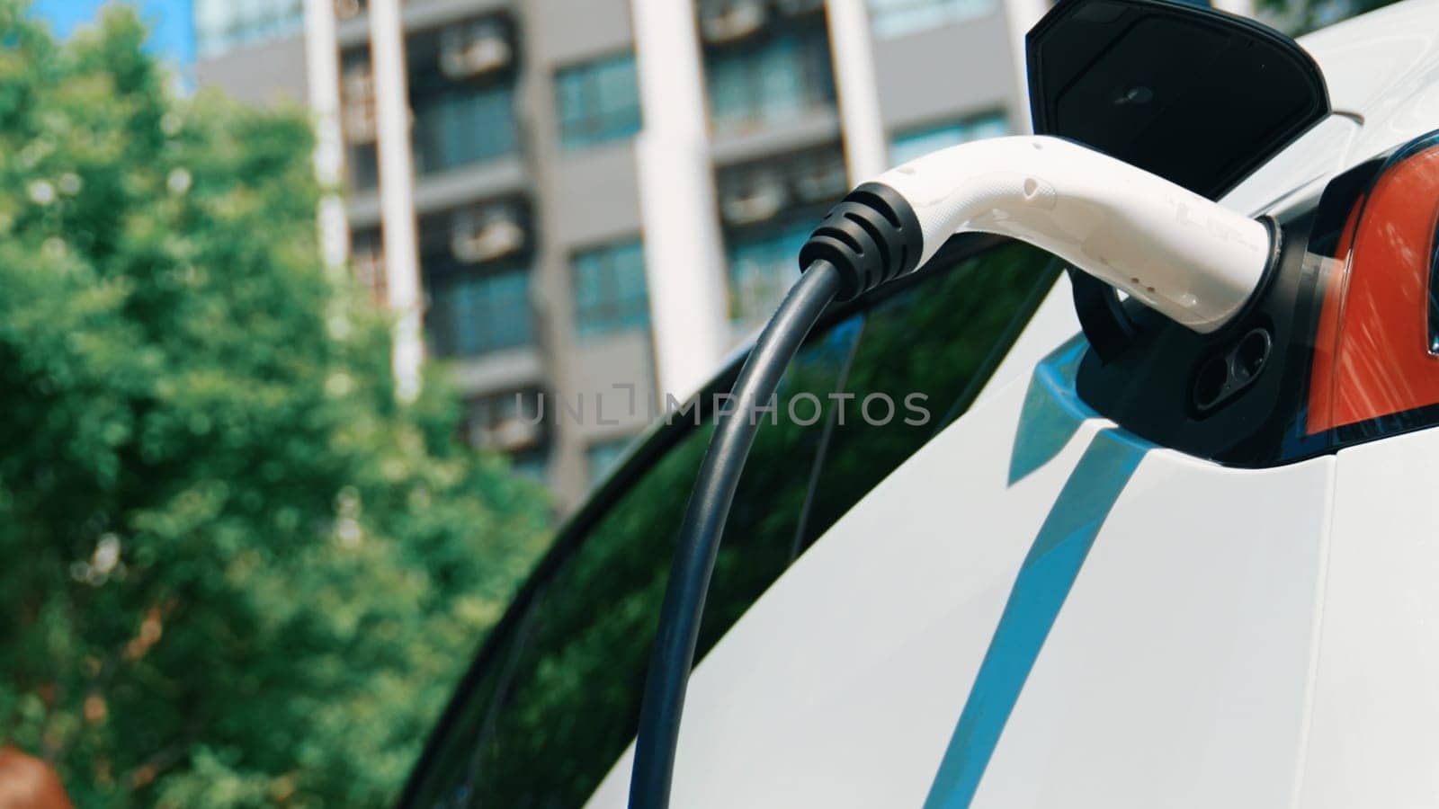 EV electric car charging in green sustainable city innards by biancoblue