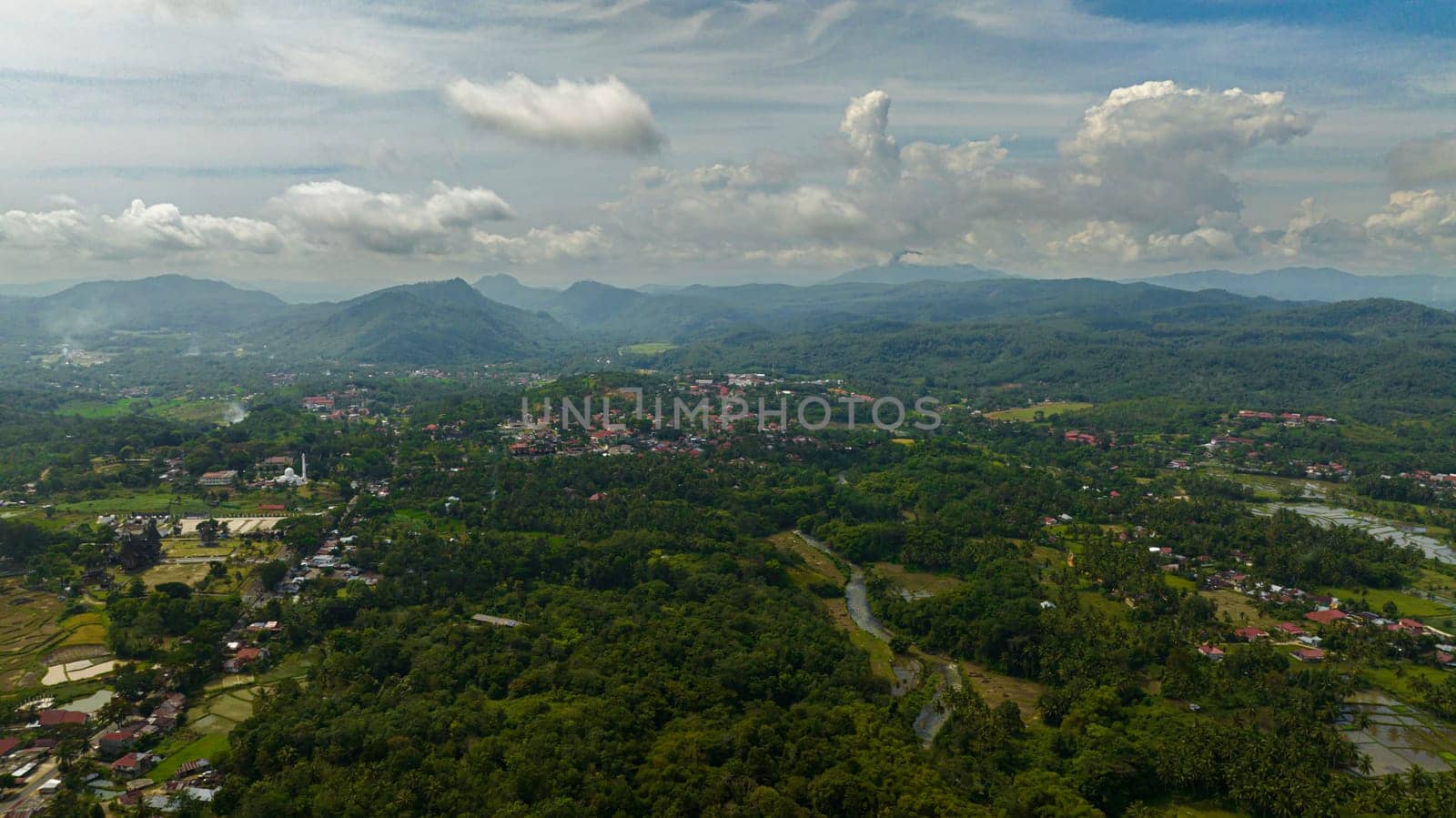 Top view of agricultural land and mountains with green forest. Farmland in the tropics. Bukittinggi, Sumatra. Indonesia.