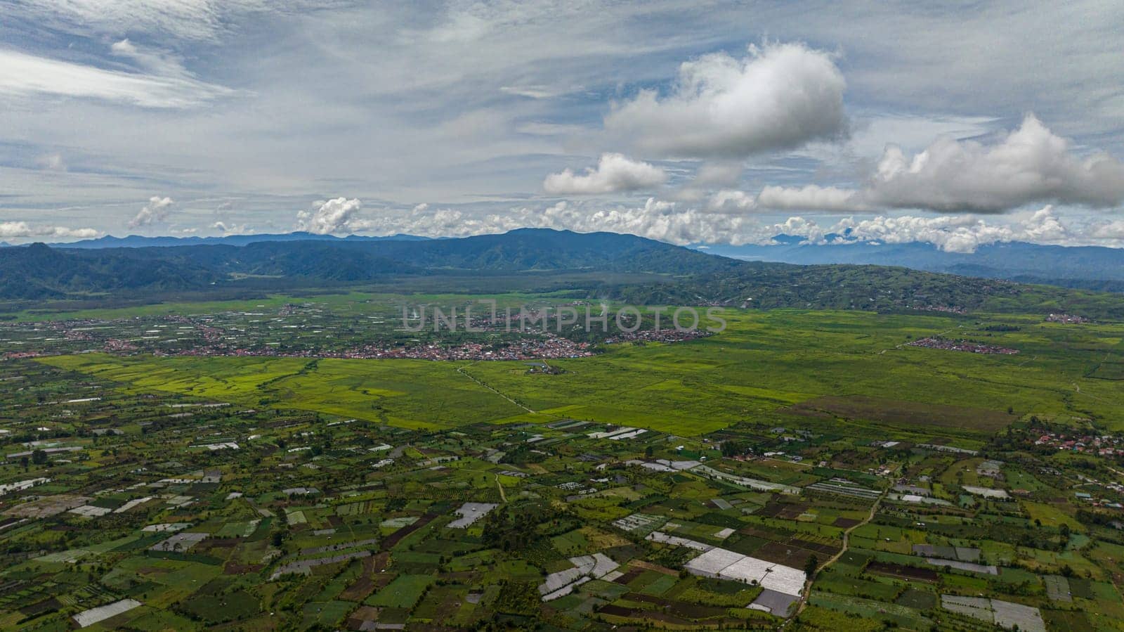 Aerial view of farm and agricultural land with crops in the mountainous area. Kayu Aro, Sumatra, Indonesia.