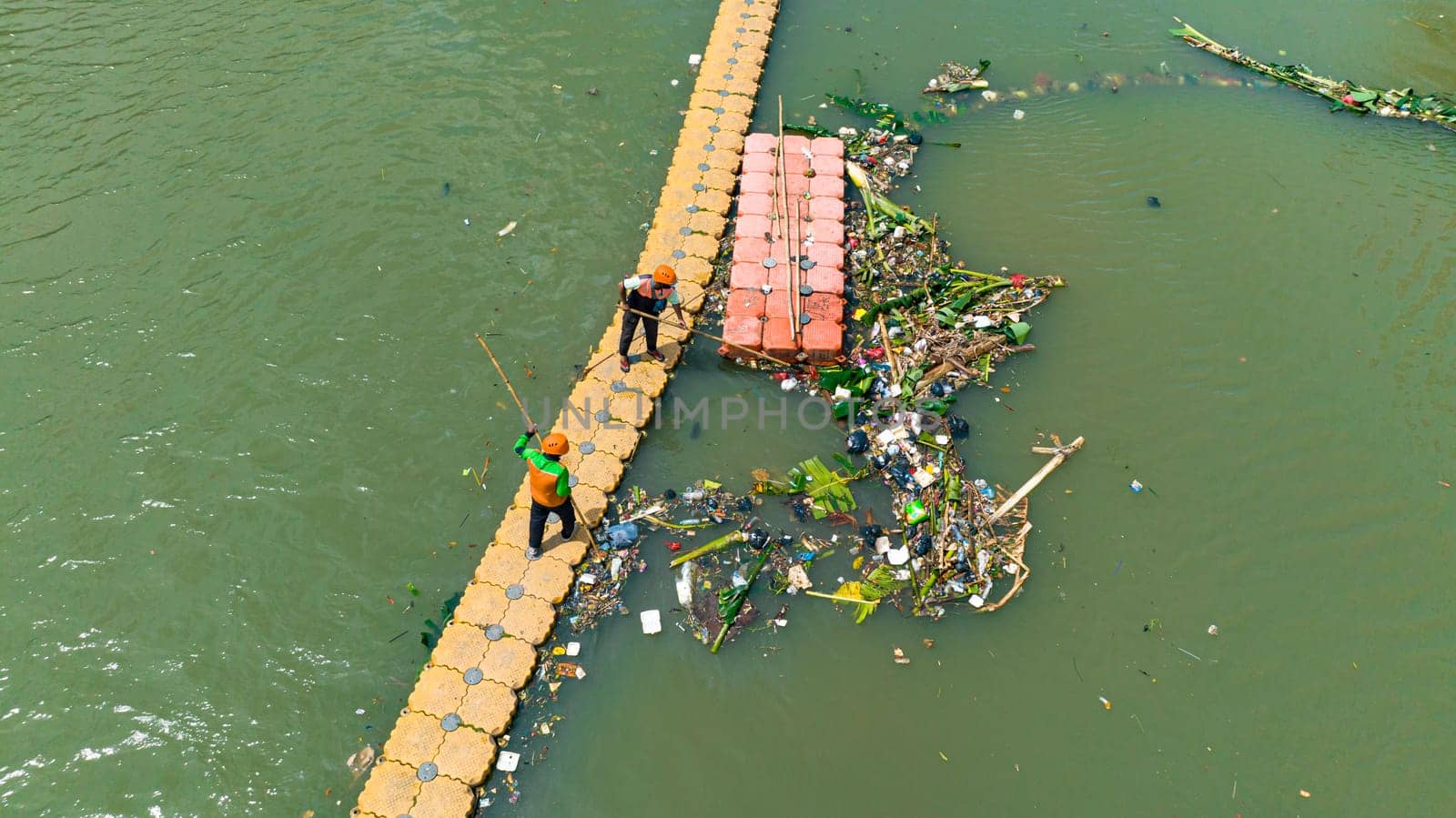 Jakarta, Indonesia - October 11, 2022: workers clean up a river of debris in Jakarta. Indonesia.