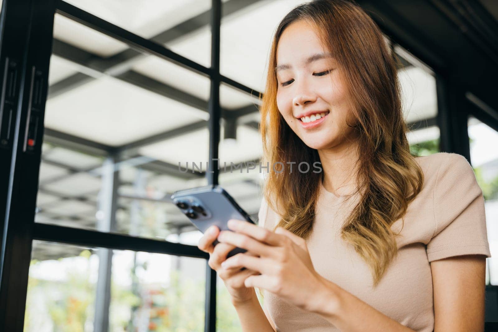 Asian young woman using smart phone for shopping online at cafe coffee shop in the morning, female has transfer money financial internet banking on mobile phone