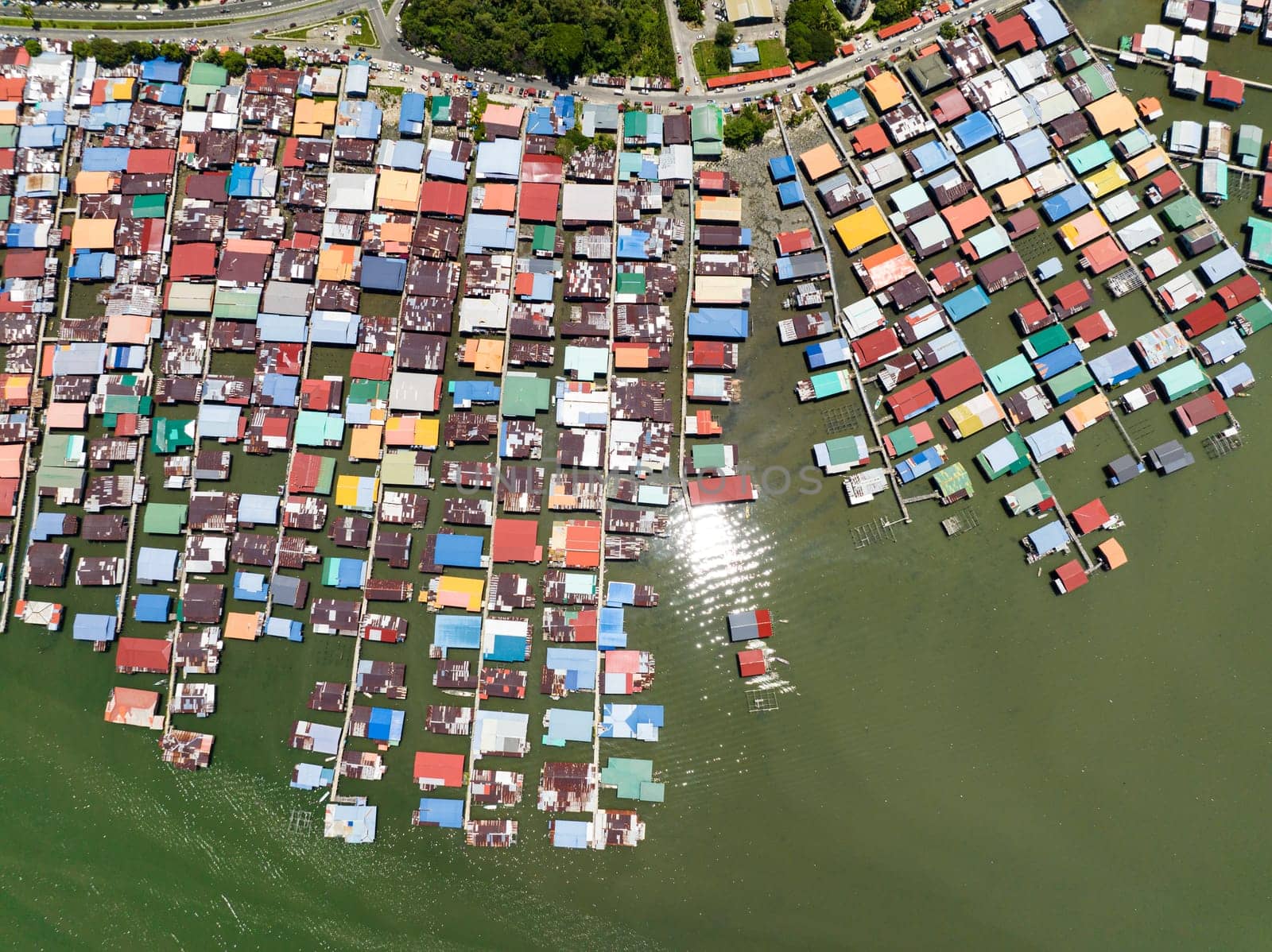 Fishing village on the island of Borneo with houses on stilts in the sea view from above. Sandakan, Malaysia.
