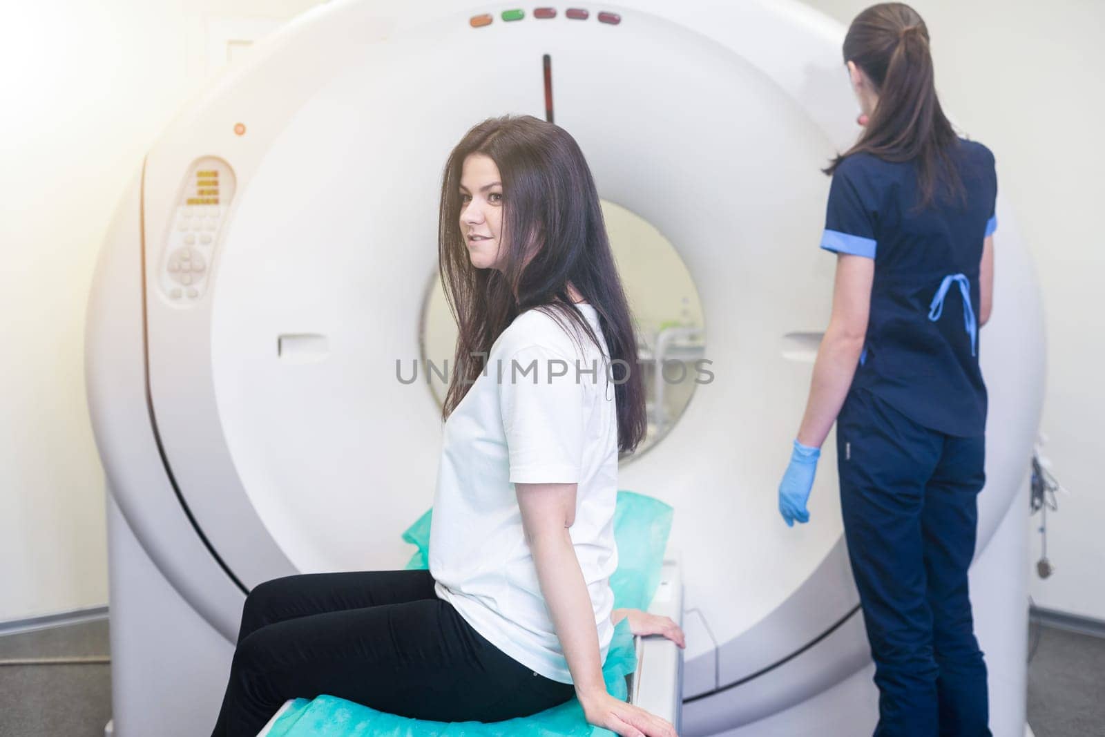 Radiologist with a female patient in the room of computed tomography by Andelov13