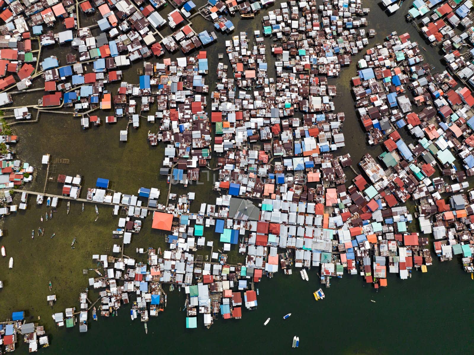 A village in Borneo with houses standing in the water on stilts view from above. Borneo, Semporna. Sabah, Malaysia.