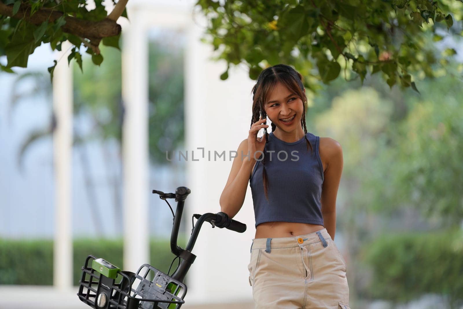 Happy Asian young woman ride bicycle in park, street city her smiling using bike of transportation, ECO friendly, People lifestyle concept by itchaznong