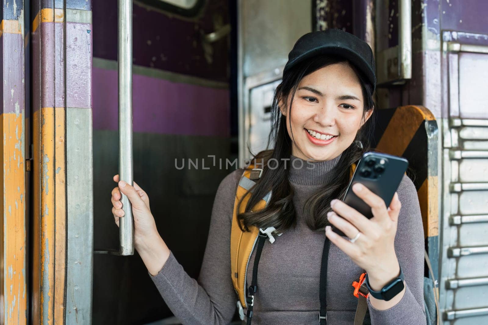 Woman using mobile phone while travel by train. travel concept by itchaznong