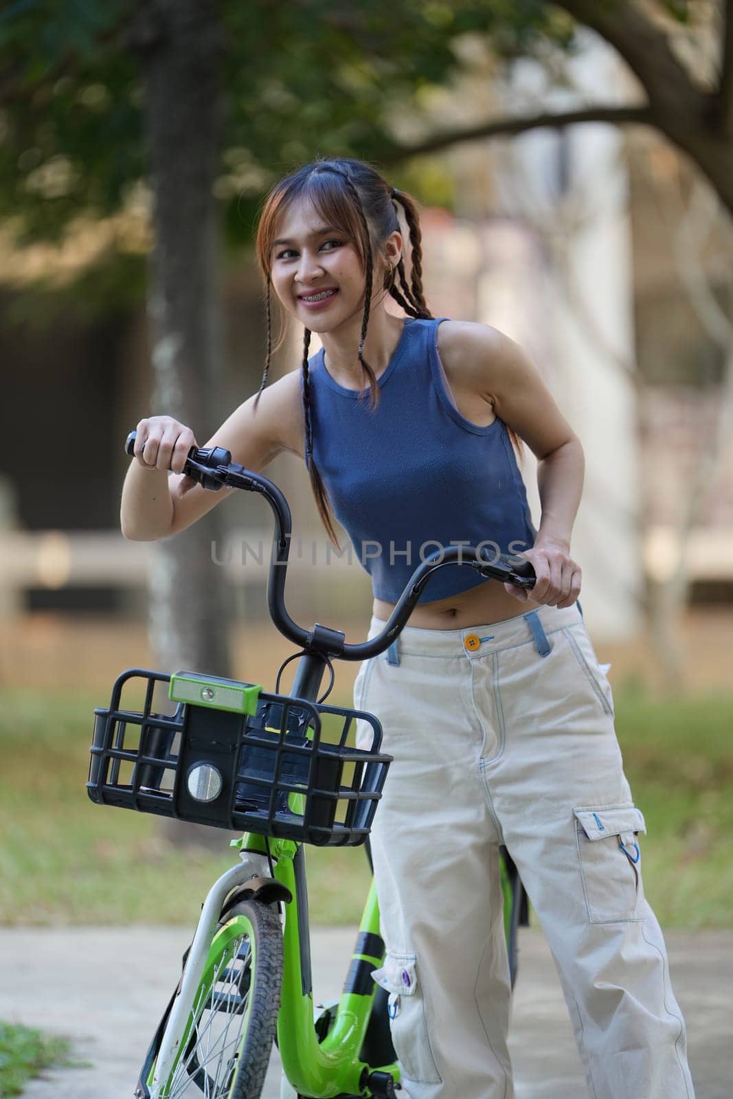 Happy Asian young woman ride bicycle in park, street city her smiling using bike of transportation, ECO friendly,, People eco lifestyle concept by itchaznong
