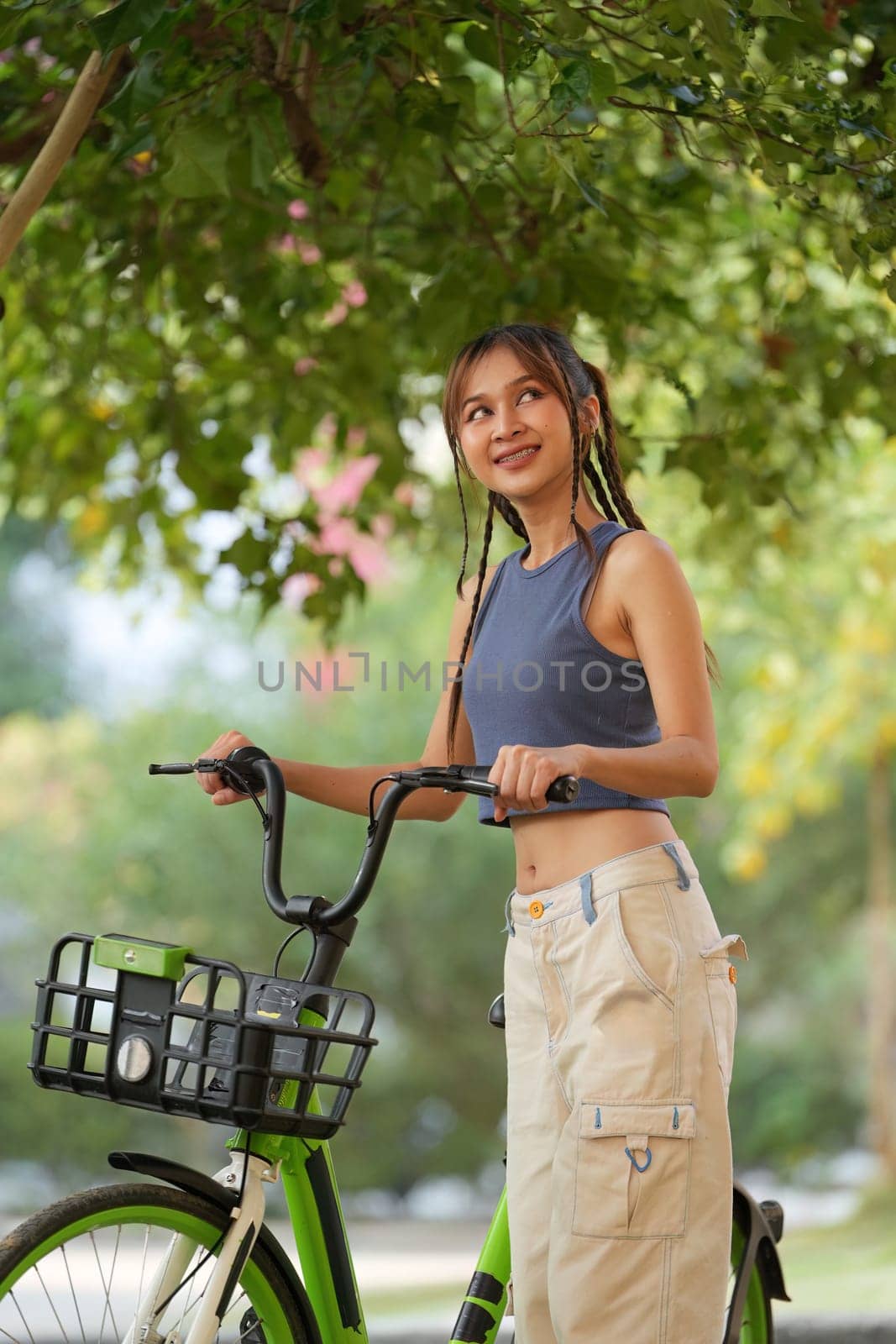 Happy Asian young woman ride bicycle in park, street city her smiling using bike of transportation, ECO friendly, People lifestyle concept by itchaznong