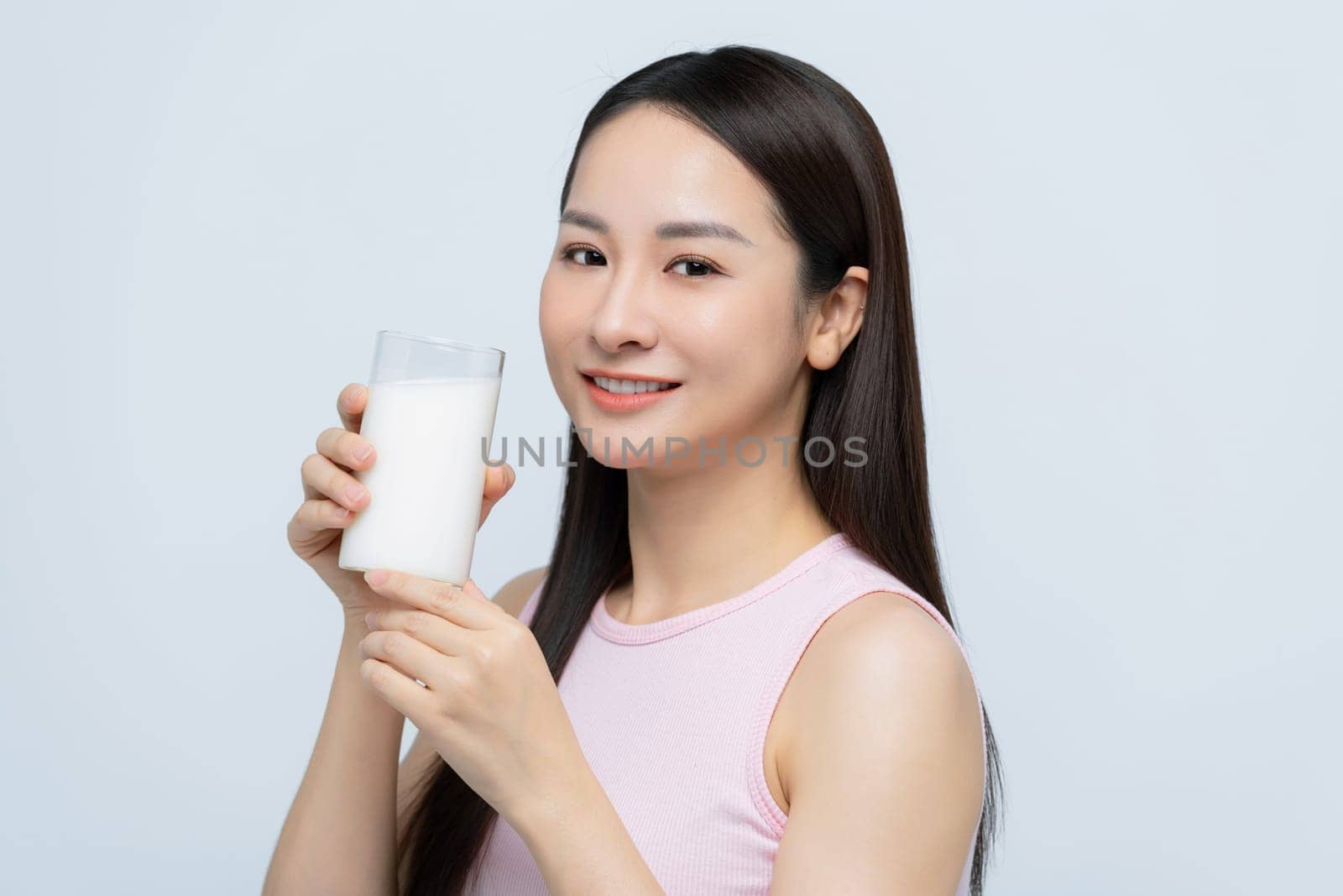 Portrait young asian woman drinking milk from the glass isolated over white background by makidotvn