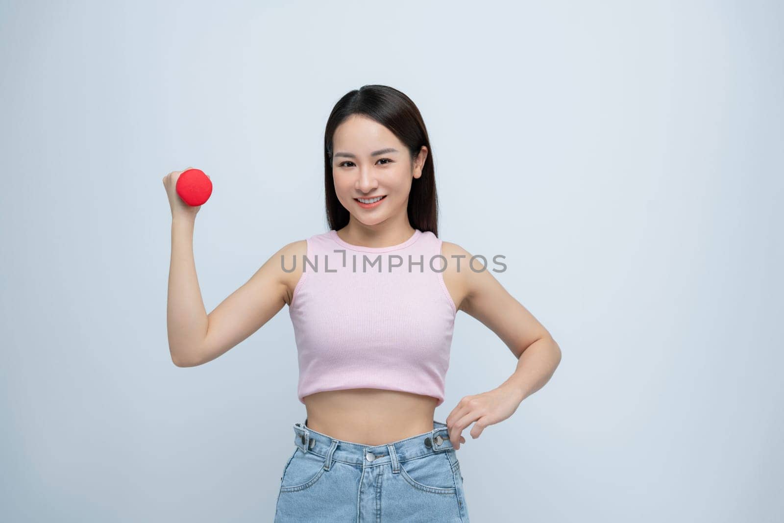 Young asian woman lifting dumbbells