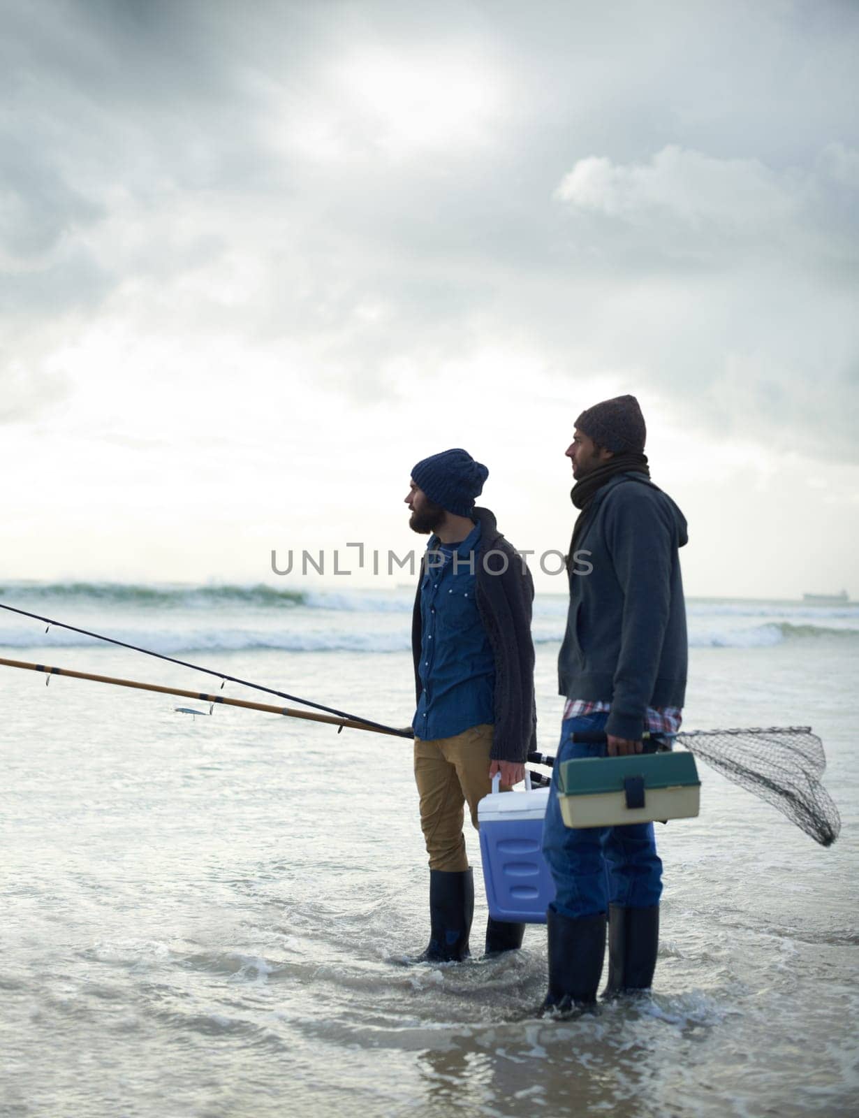 Fisherman, friends and gear on beach for fishing in the morning by sea with overcast, equipment and sky. Friendship, men and net with bonding, travel or rod by water for hobby, holiday or activity.