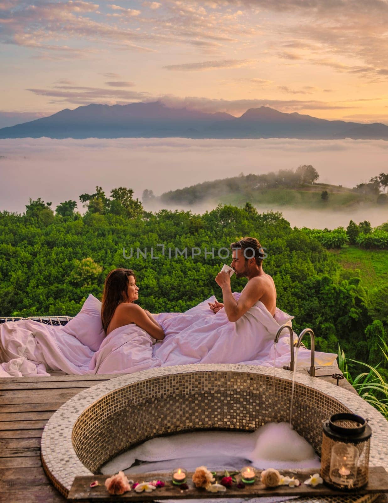 couple of men and women in a bathtub looking out over the mountains of Northern Thailand by fokkebok
