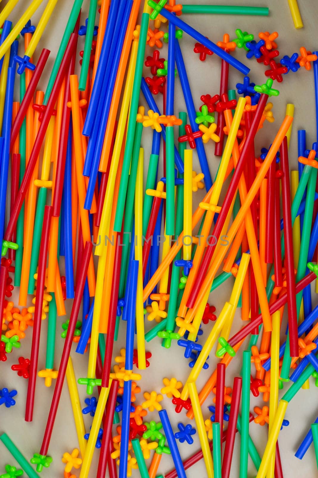 Flexible construction set tubes with special connection are scattered on the table, mess on the children play area in the room, modern construction set