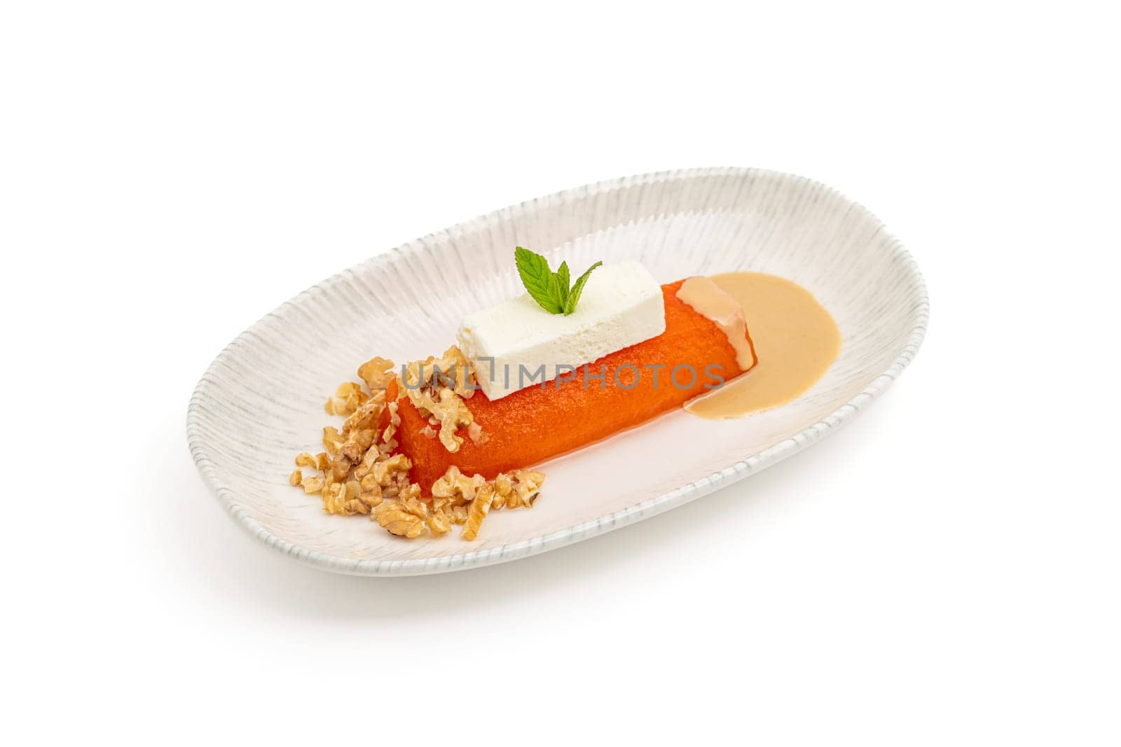 Pumpkin dessert with tahini and walnuts on a white porcelain plate