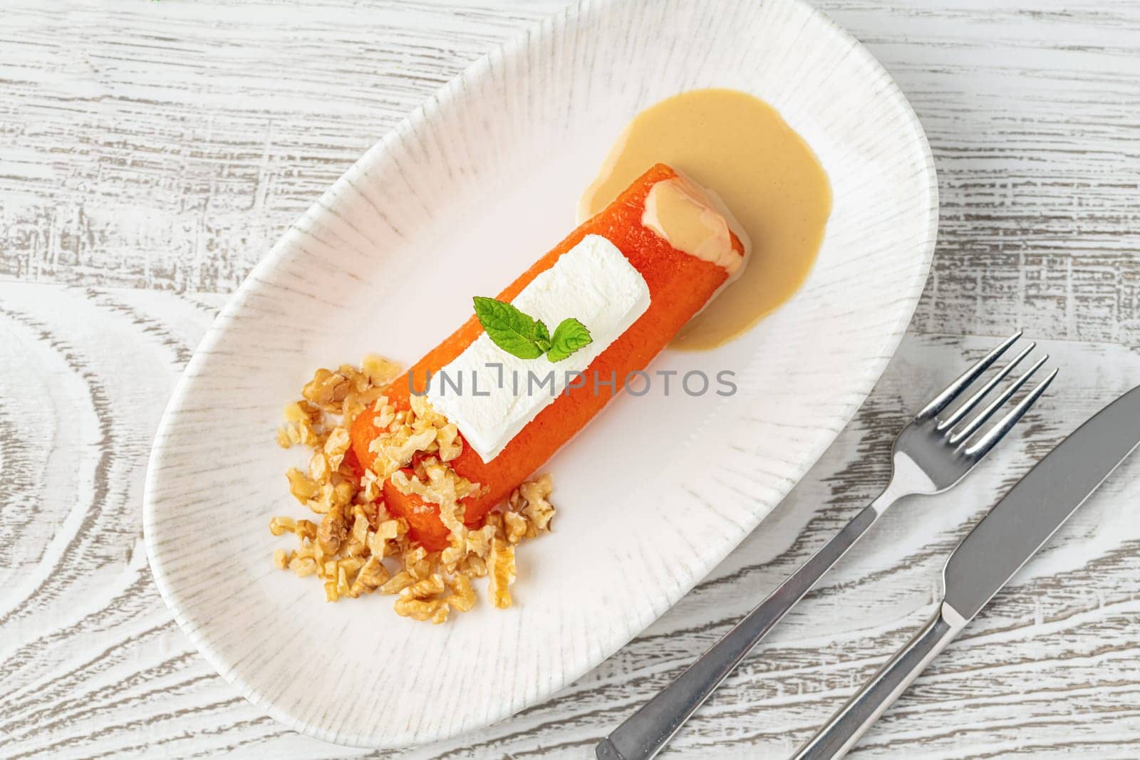 Pumpkin dessert with tahini and walnuts on a white porcelain plate by Sonat