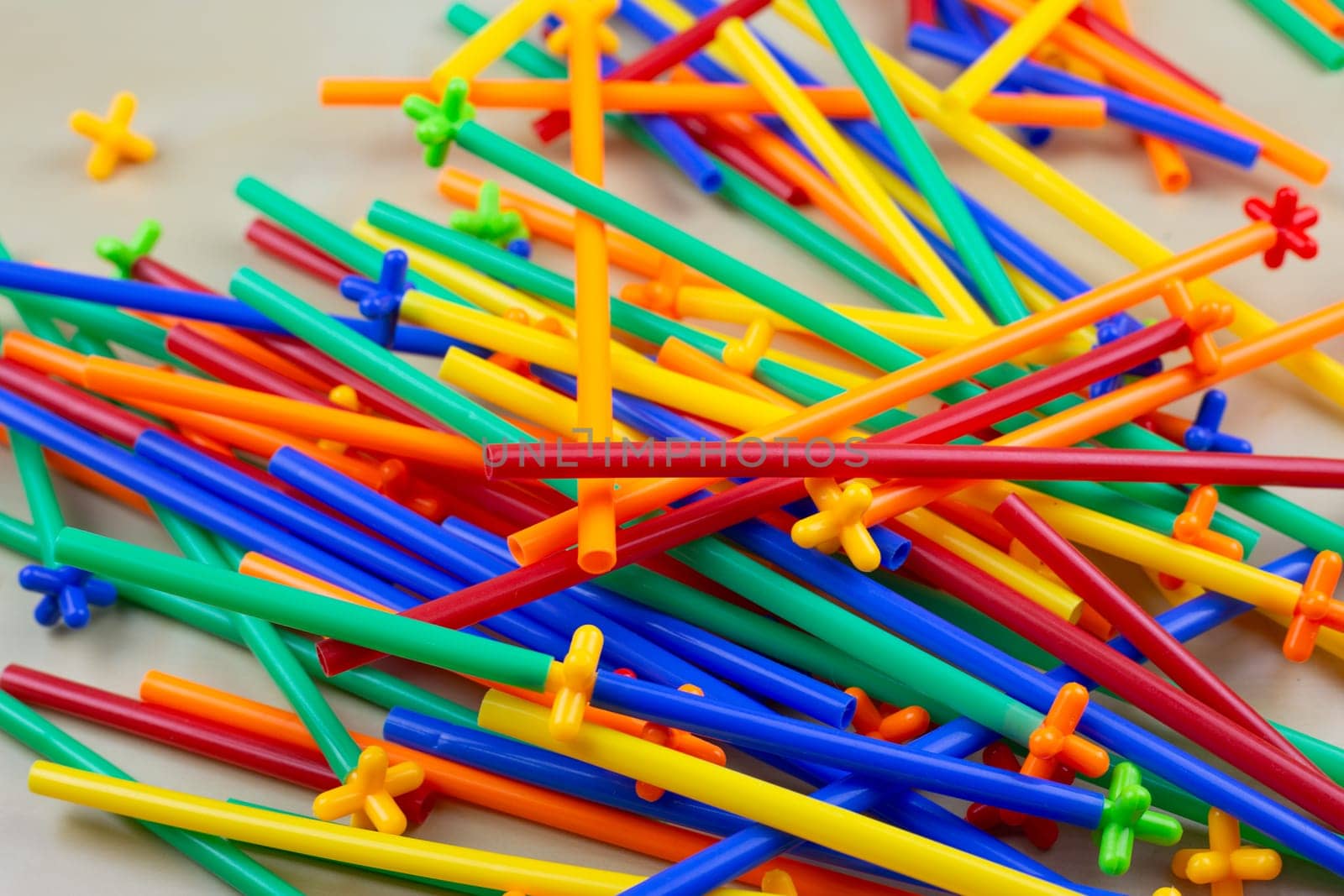 Scattered parts of flexible construction set on table in a children room, close up photo of mess with construction set parts