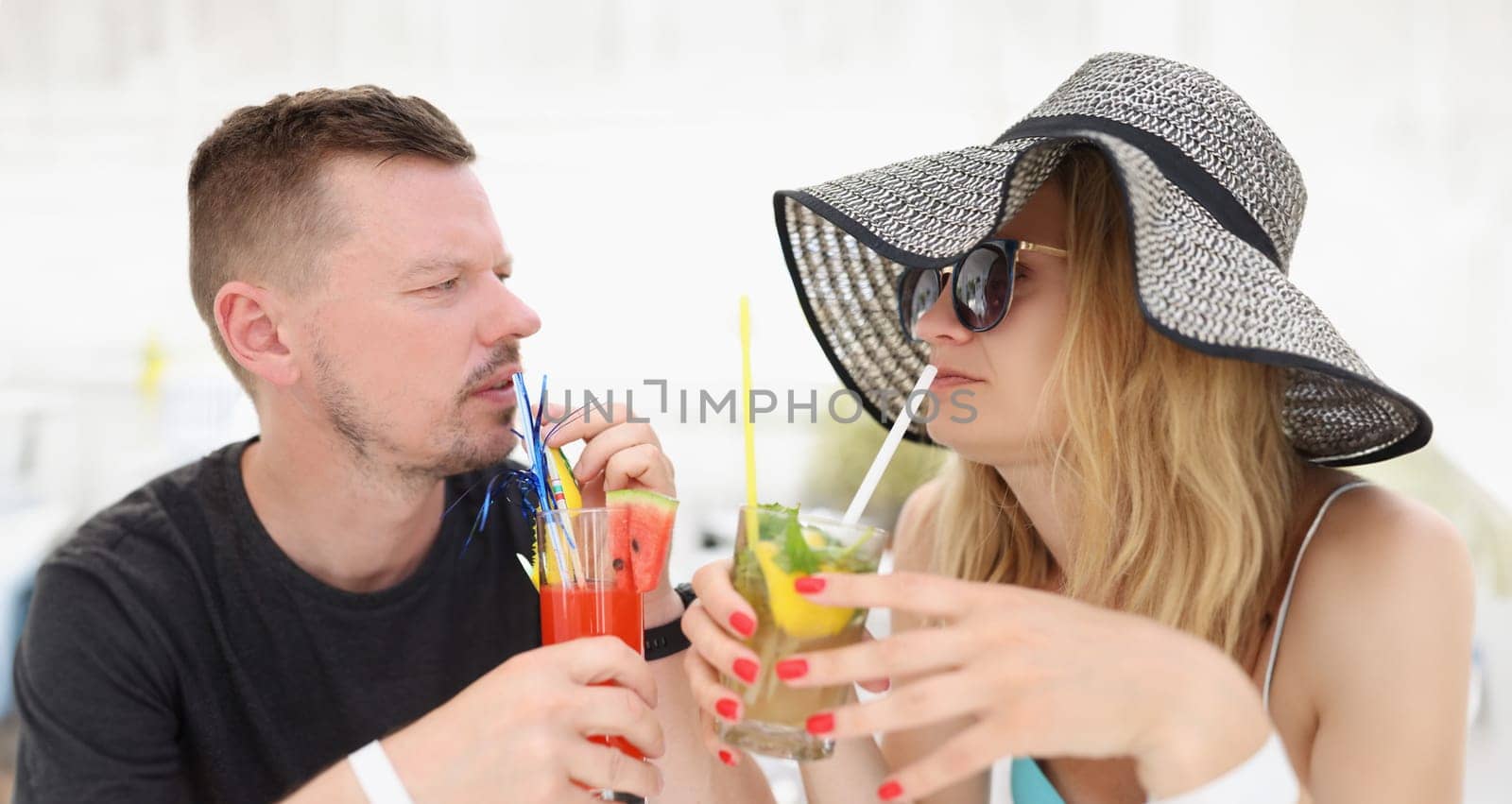A couple on vacation drinking tropical cocktails, close-up by kuprevich