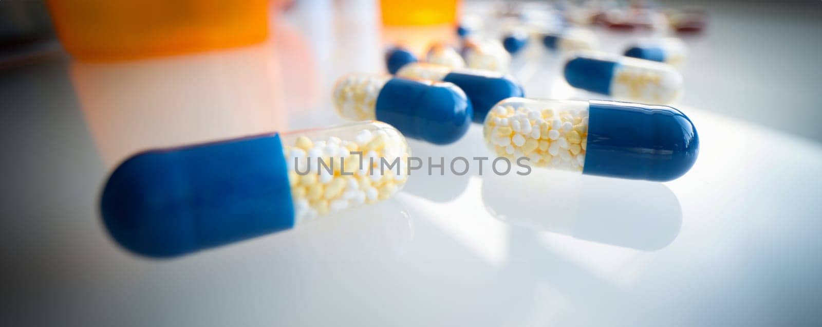 White blue capsules lie on the table, close-up, blurry. Medical product, pharmacology, dietary supplements