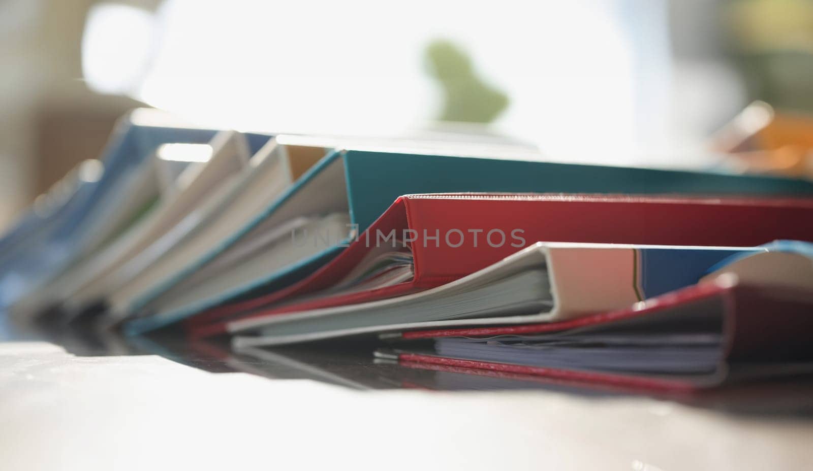 Colored folders lie on the table, close-up, blurry. Archive with documents, accountant's workplace, business