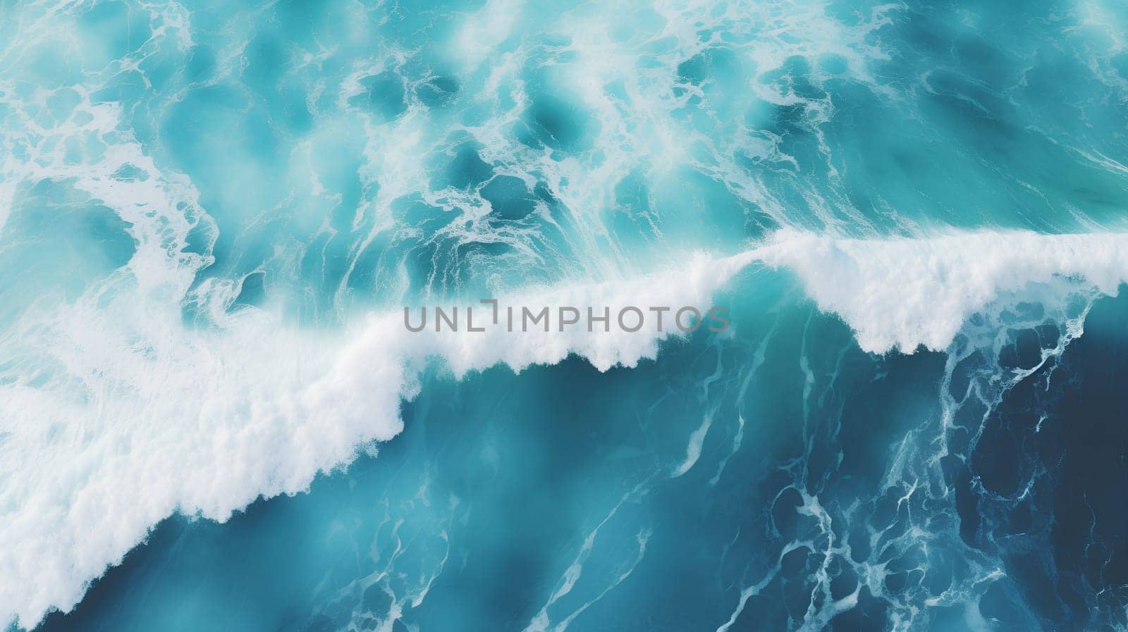 Aerial view of a turquoise ocean wave cresting with white foam against deep blue water. High quality photo