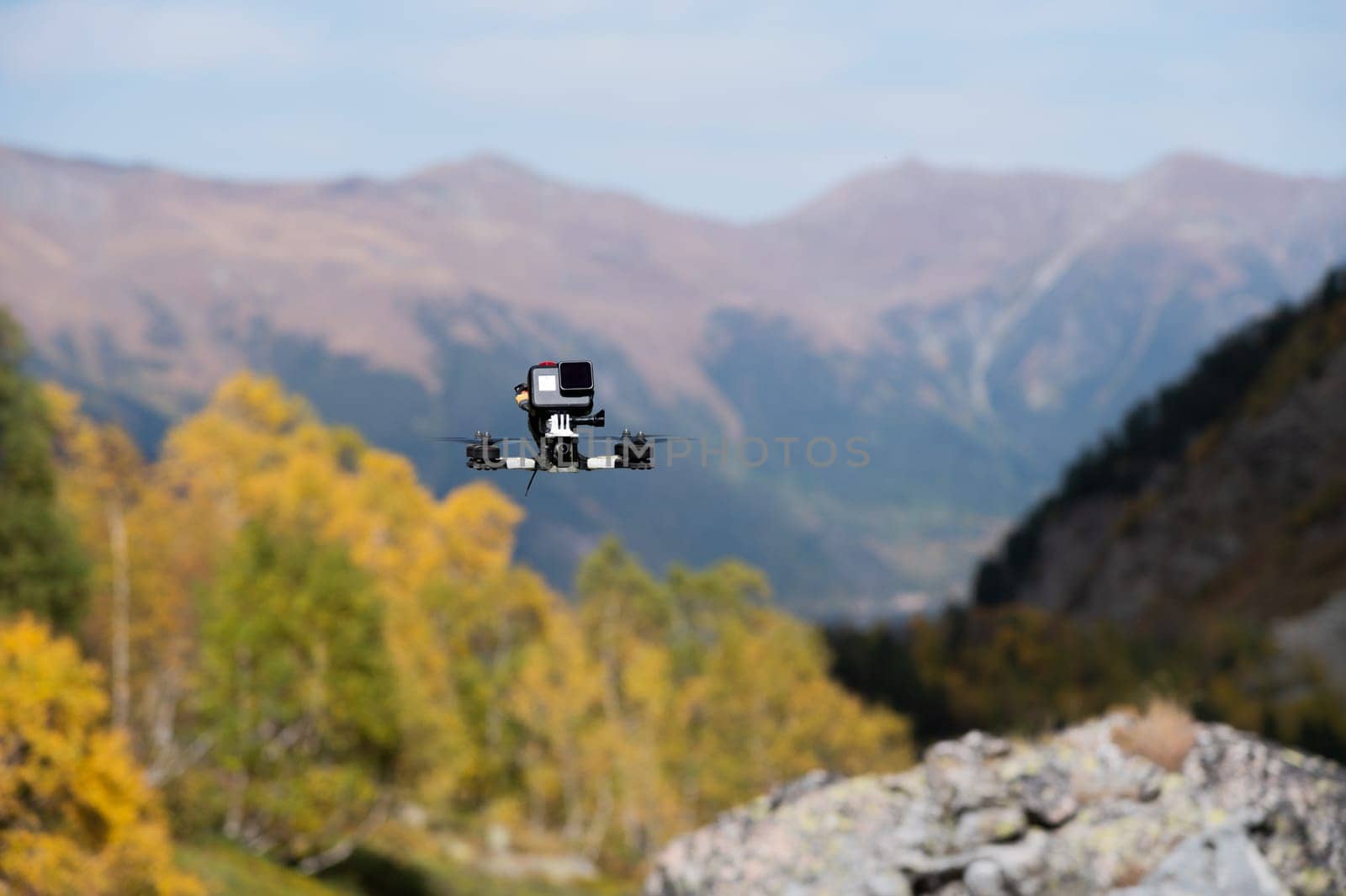 FPV drone hovering in the air, filming a forest in the mountains with an action camera attached to the drone by yanik88