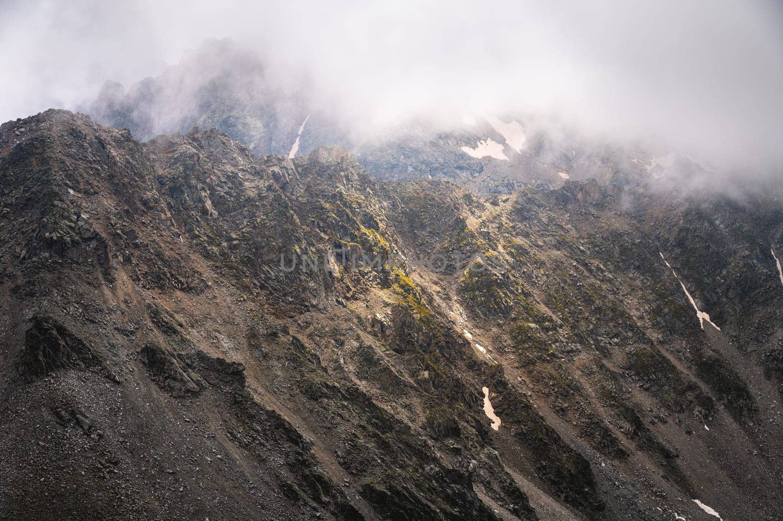 Fog and cold on one of the peaks in the mountains. Mystical atmosphere over the mountain range.