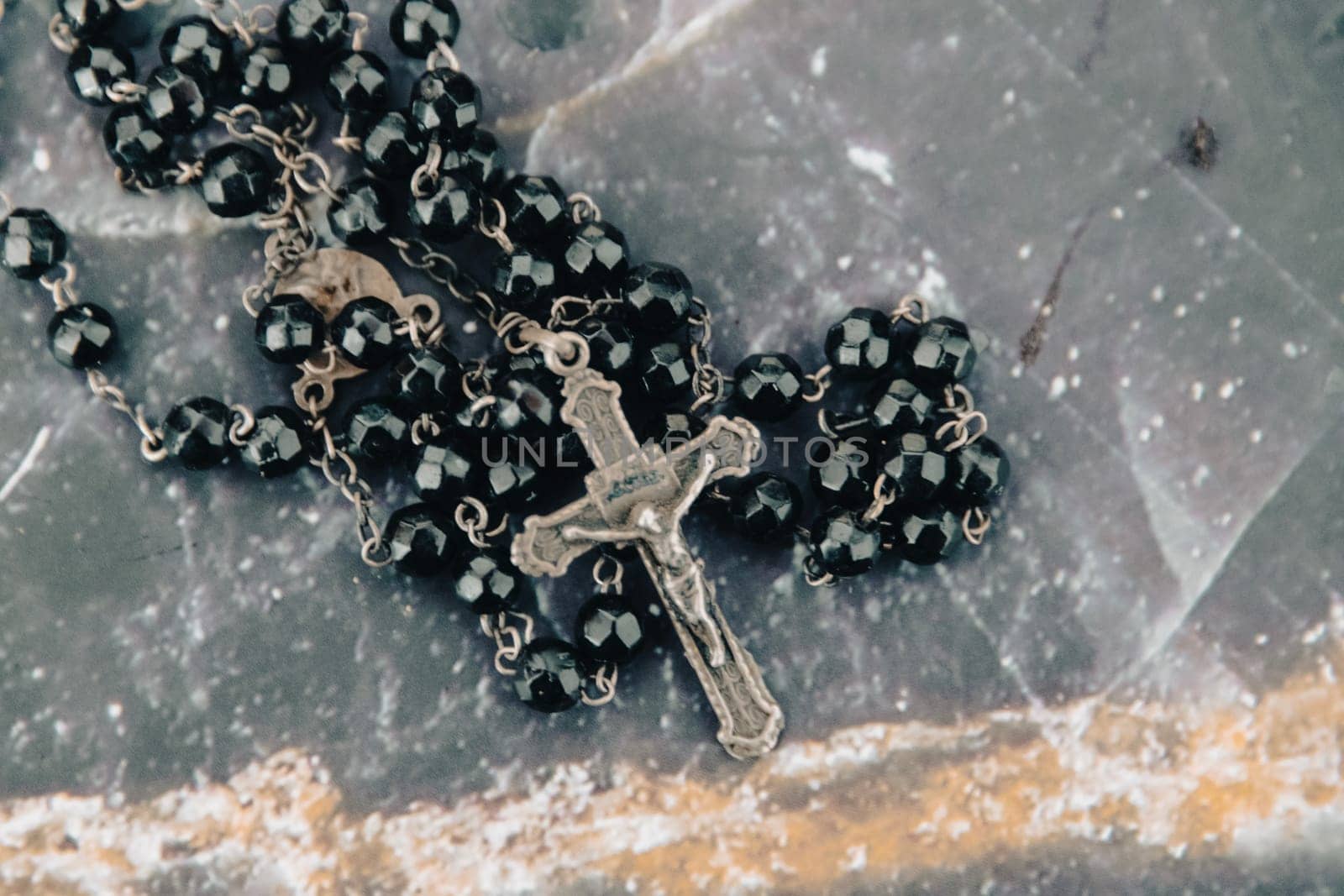 A close-up shot of a black beaded rosary and crucifix, symbolizing faith and spirituality
