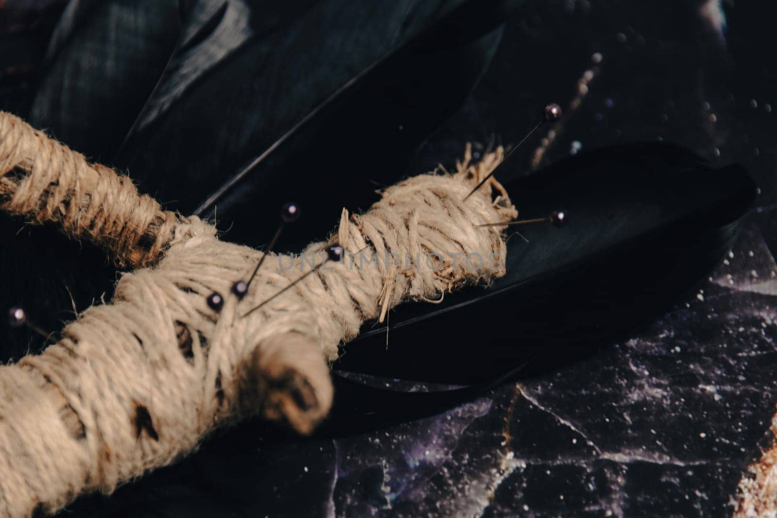 A handmade voodoo doll with pins, set against a rustic backdrop, evoking occult practices