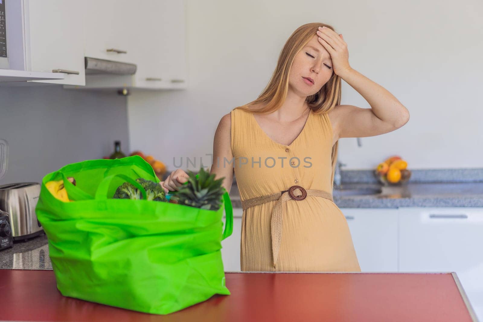 Exhausted but resilient, a pregnant woman feels fatigue after bringing home a sizable bag of groceries, showcasing her dedication to providing nourishing meals for herself and her baby by galitskaya