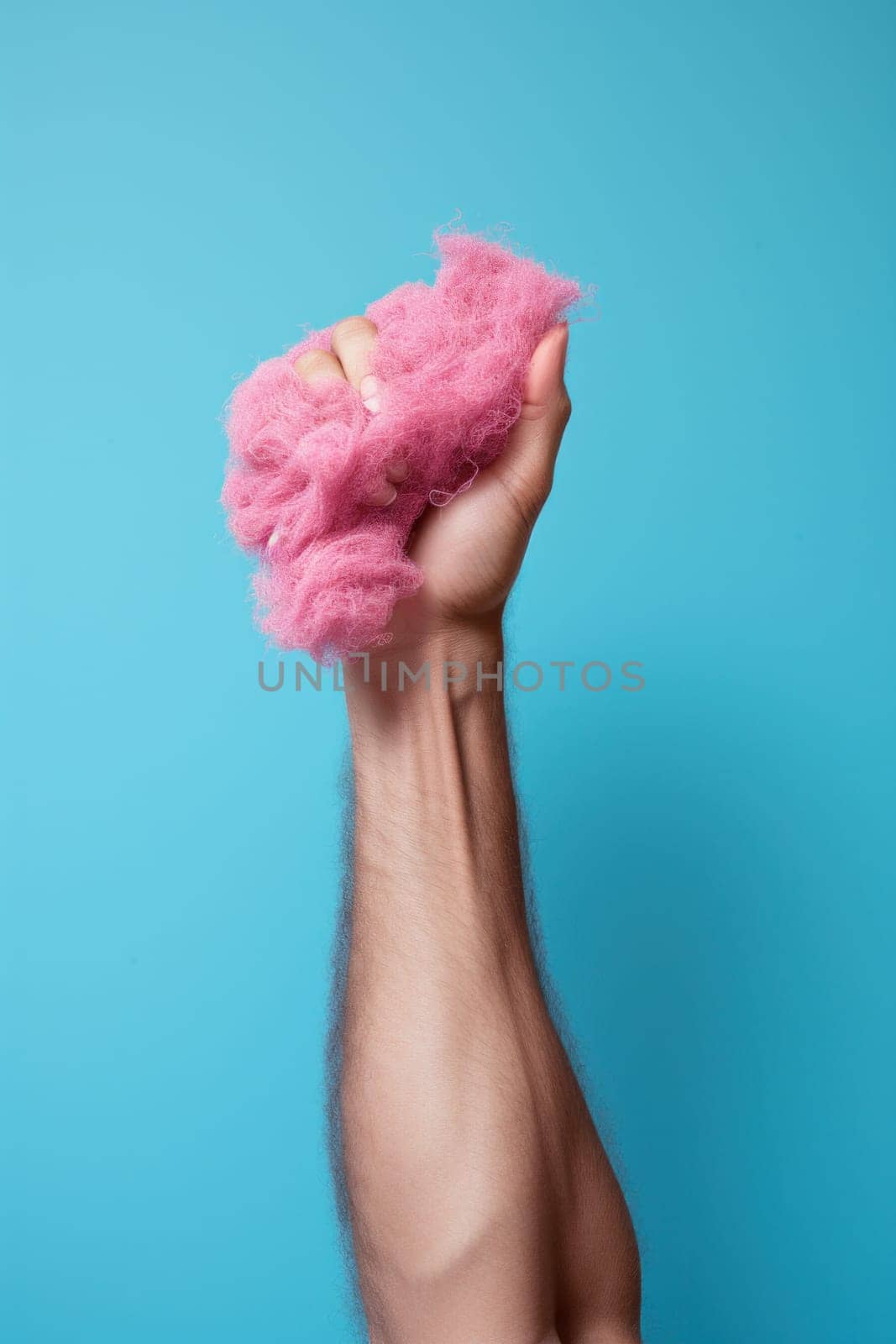 A man's arm holding a pink cotton ball in his fist, AI by starush