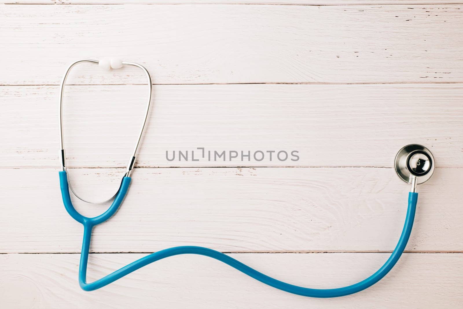 Top view blue medical stethoscope on wooden background by Sorapop