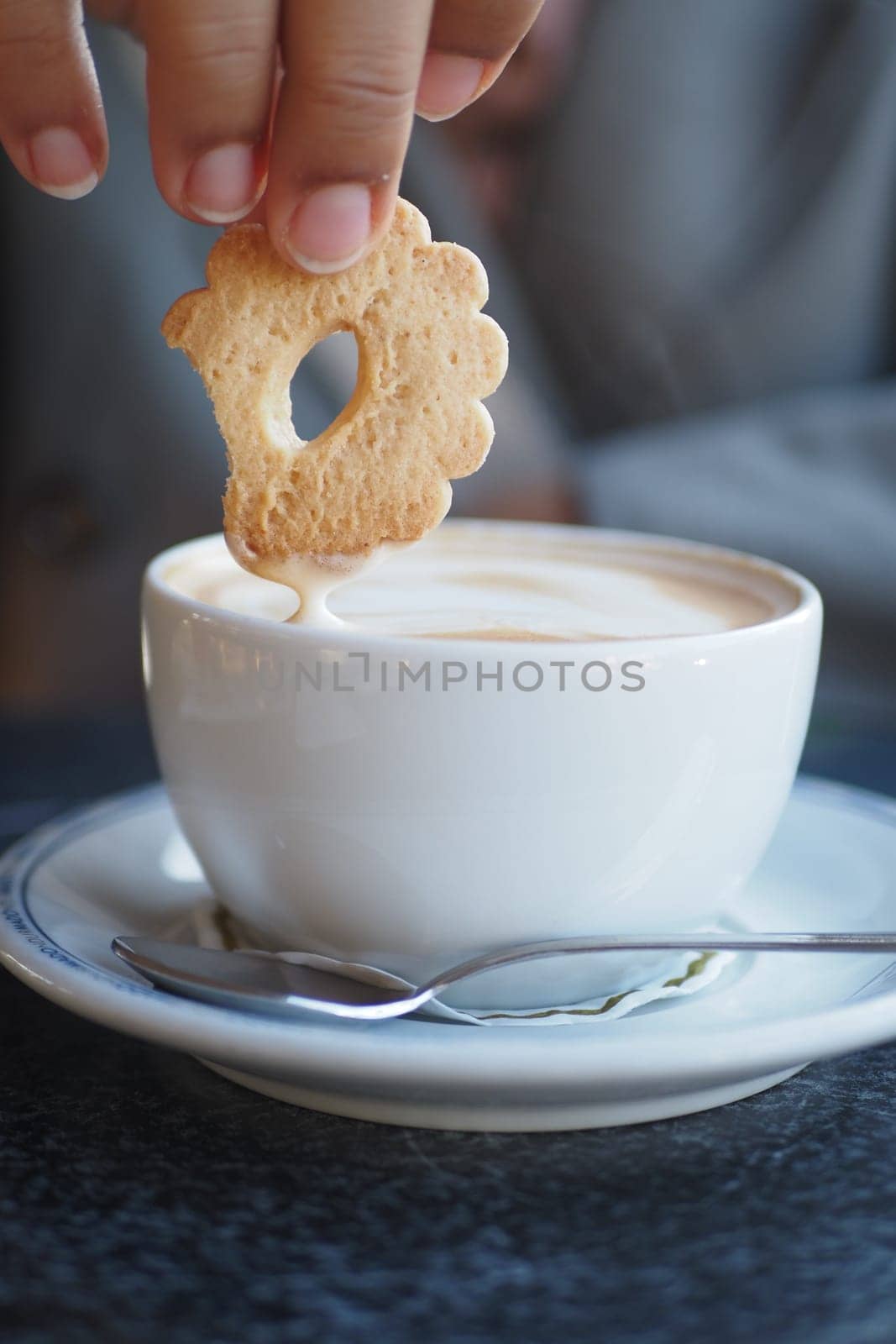 pouring sweet cookies in a coffee mug on wooden table by towfiq007