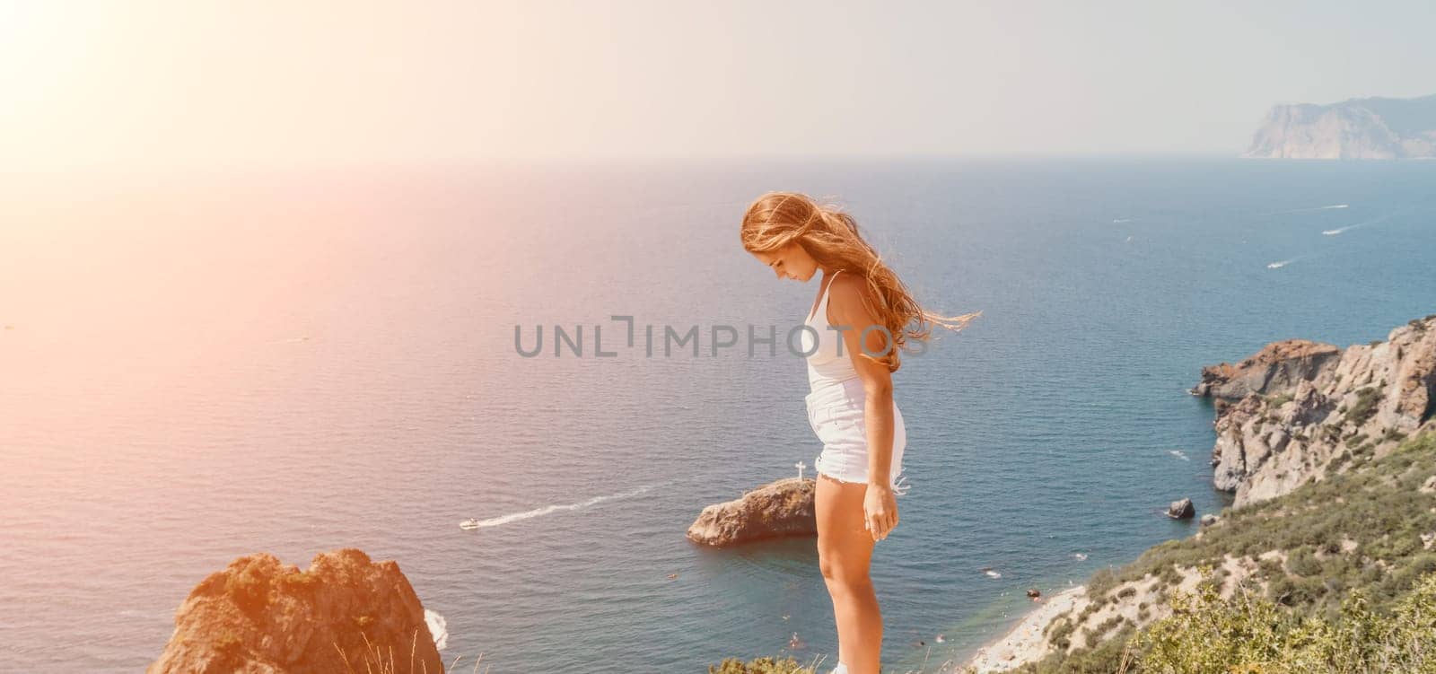 Woman summer travel sea. Happy tourist enjoy taking picture outdoors for memories. Woman traveler posing over sea bay surrounded by volcanic mountains, sharing travel adventure journey by panophotograph