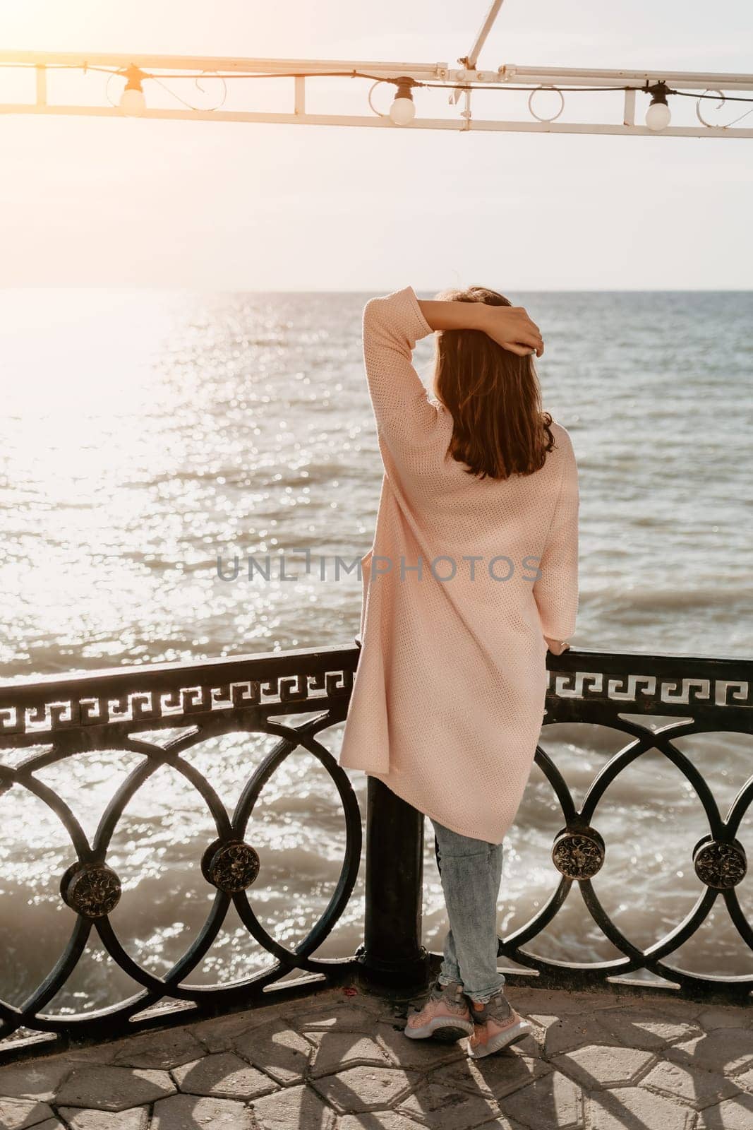 Woman summer travel sea. Happy tourist enjoy taking picture outdoors for memories. Carefree woman traveler posing on beach at sea on sunset, sharing travel adventure journey. Holiday vacation concept. by panophotograph
