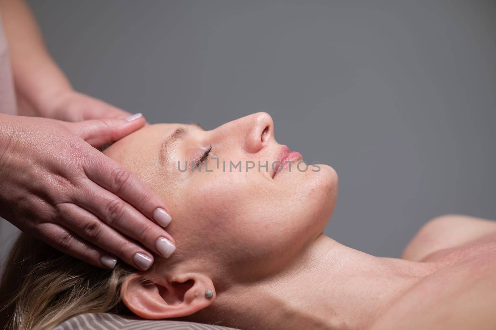 Caucasian woman undergoing head and face massage procedure