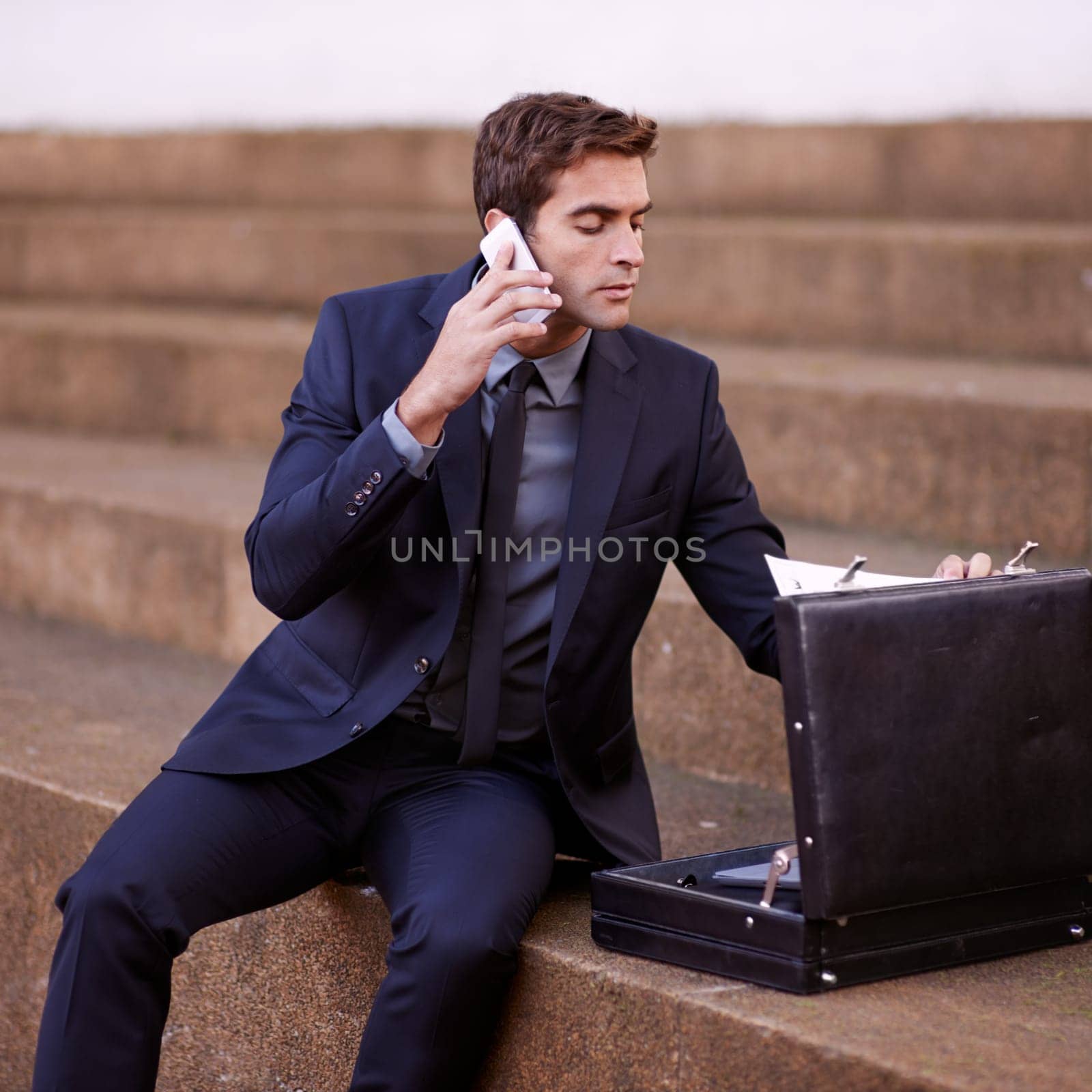 Phone call, briefcase and business man in city for Corporate, communication and contact. Networking, technology and conversation with male employee outdoors for feedback, planning and chat with paper by YuriArcurs