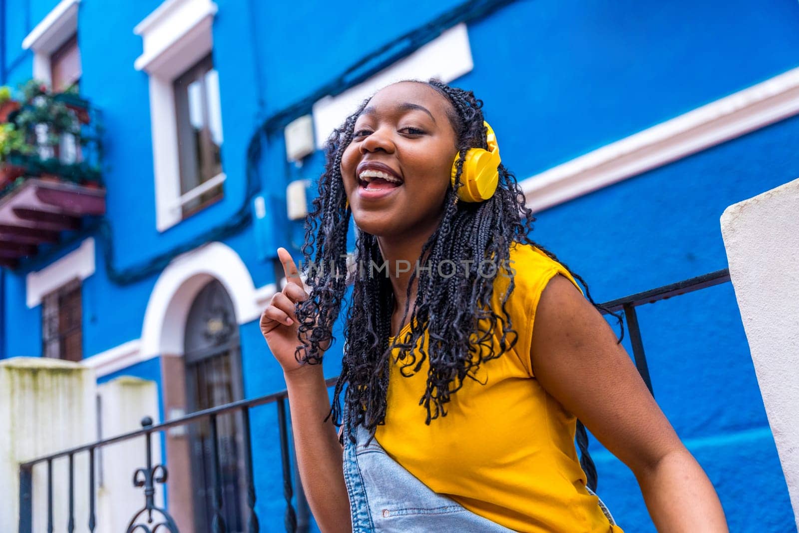 African woman singing to the camera dancing in the street by Huizi