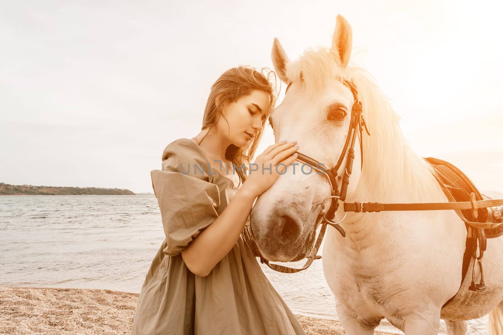A woman in a dress stands next to a white horse on a beach, with the blue sky and sea in the background. by Matiunina