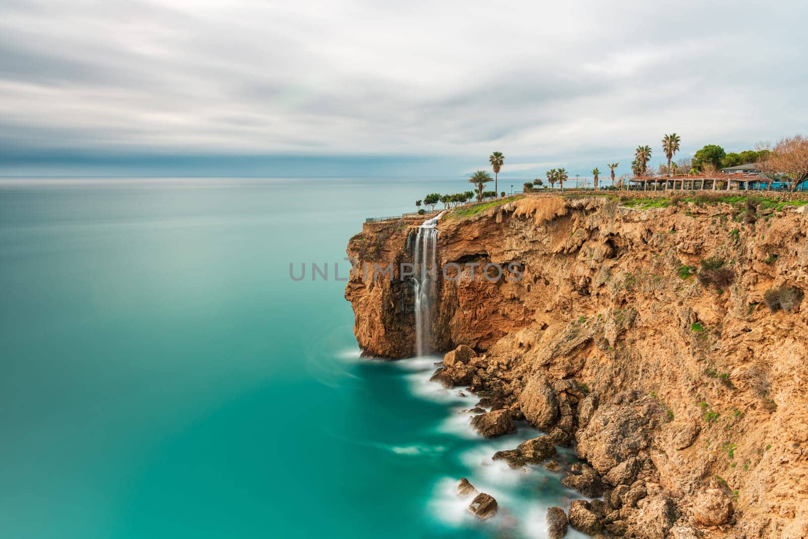 Long exposure image of the waterfall falling from the cliffs into the sea in Fener, Antalya
