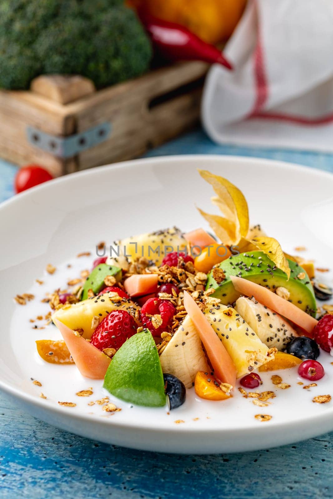 Mixed fruit salad with fruits such as banana, strawberry and pineapple on a white porcelain plate