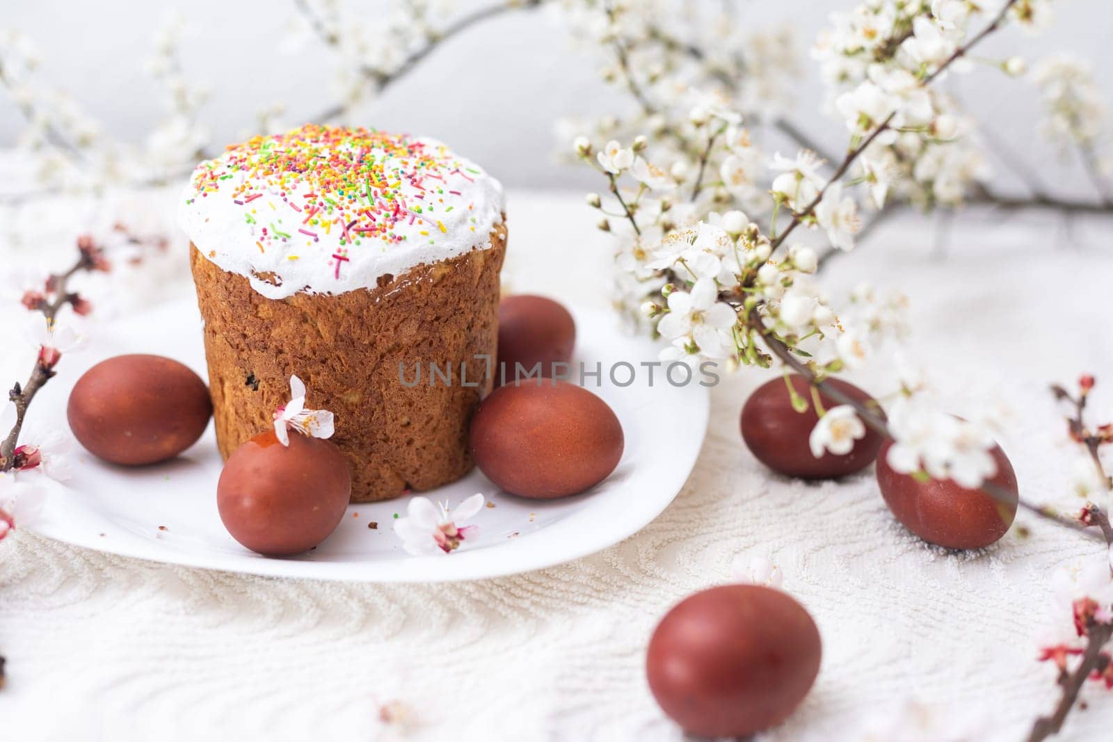 Easter background with colored eggs, colored easter eggs and blooming branches. Easter composition. Easter cake.