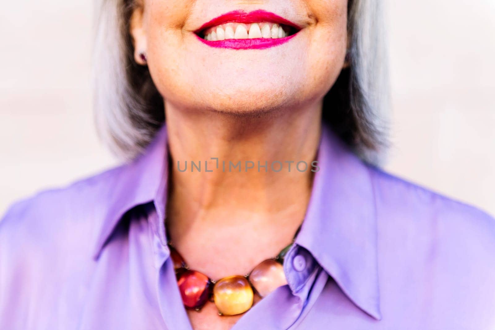detail of the mouth of a nice senior woman smiling showing her teeth, concept of happiness of elderly people and active lifestyle