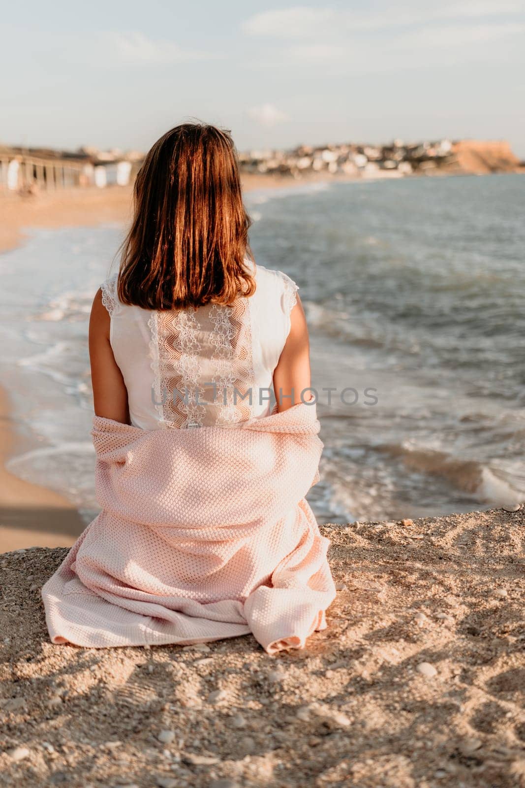 Woman travel sea. Young Happy woman in a long red dress posing on a beach near the sea on background of volcanic rocks, like in Iceland, sharing travel adventure journey