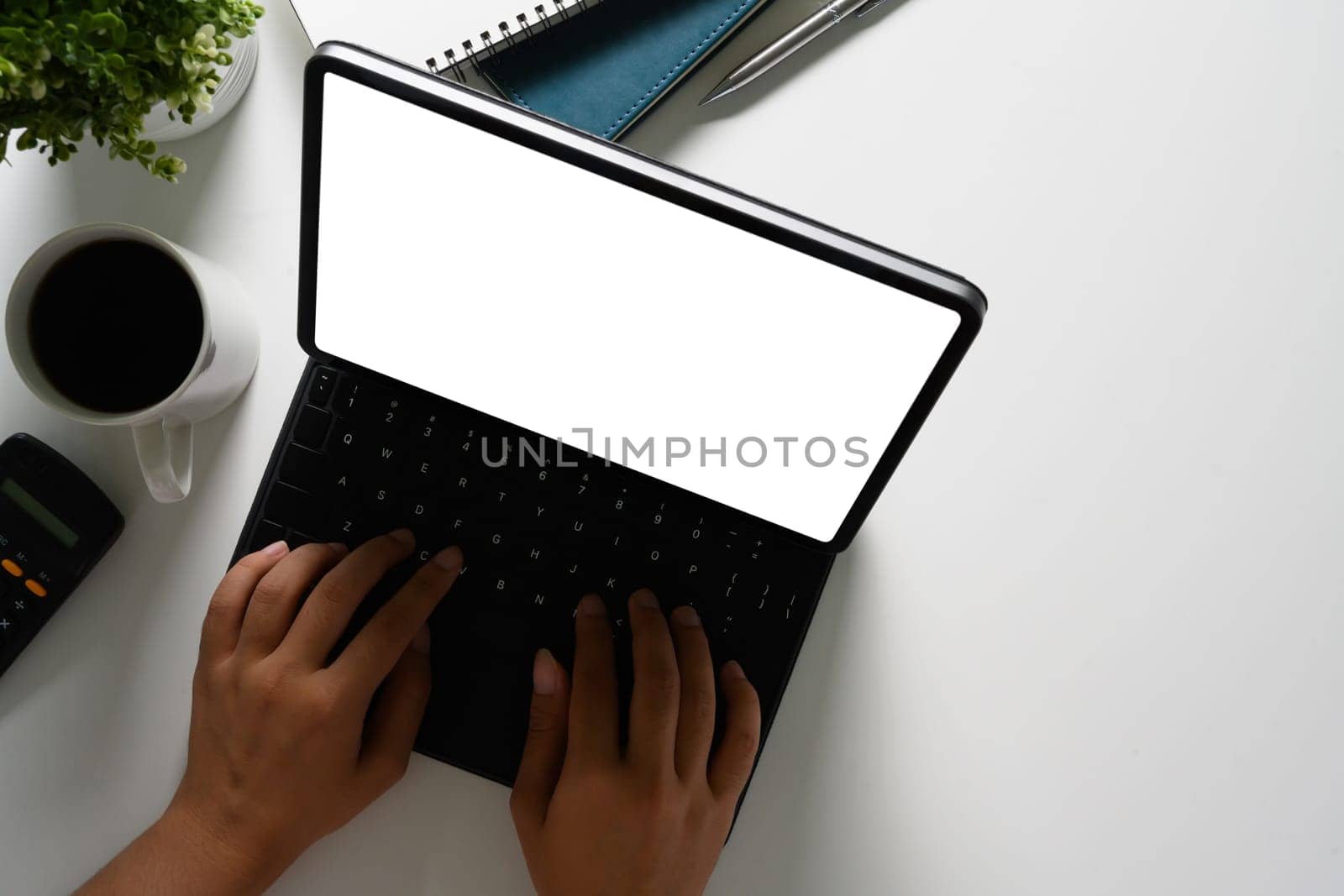 Businessman hands typing, working with digital tablet on white office desk.