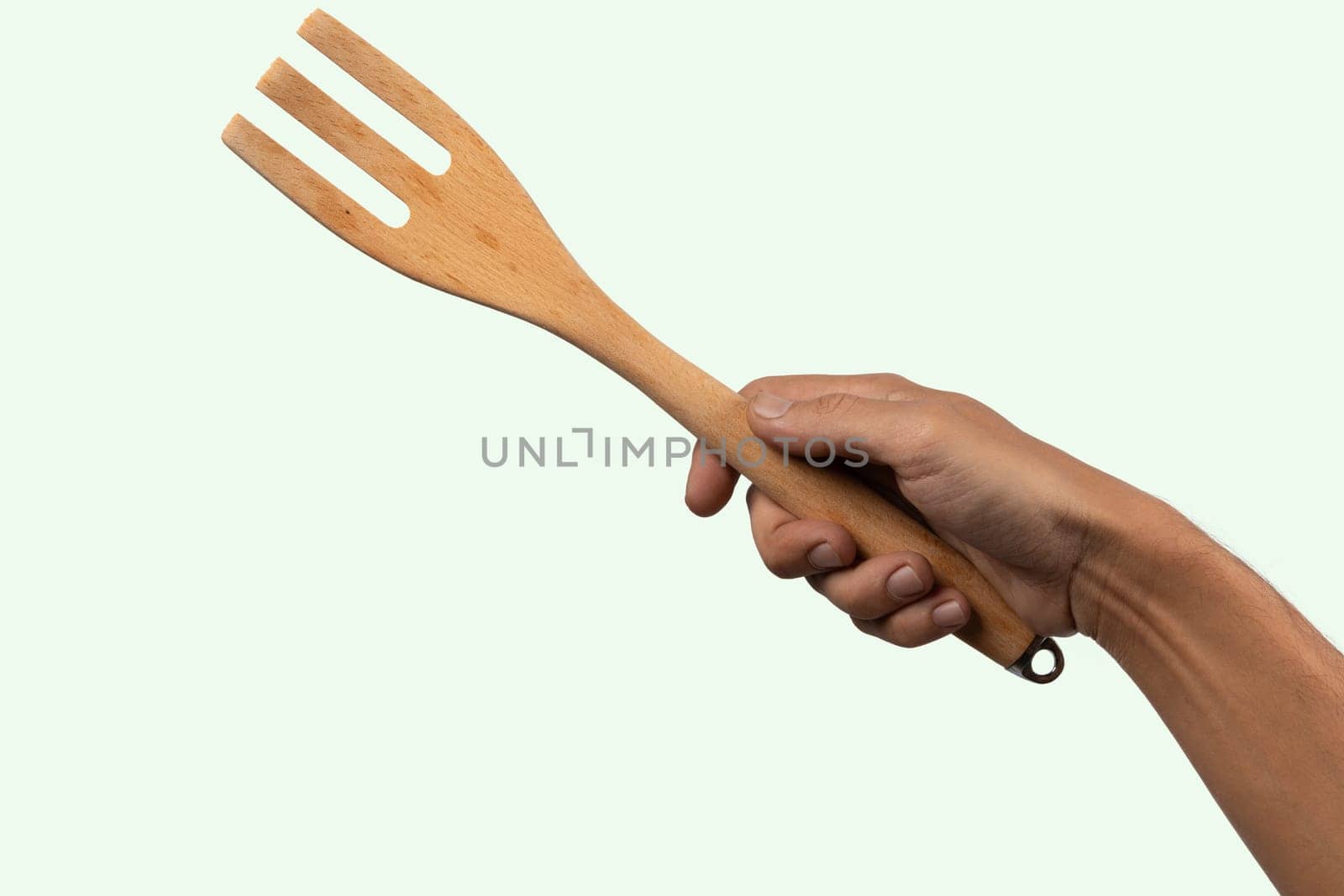 Hand holding wooden fork no background cutout. High quality photo
