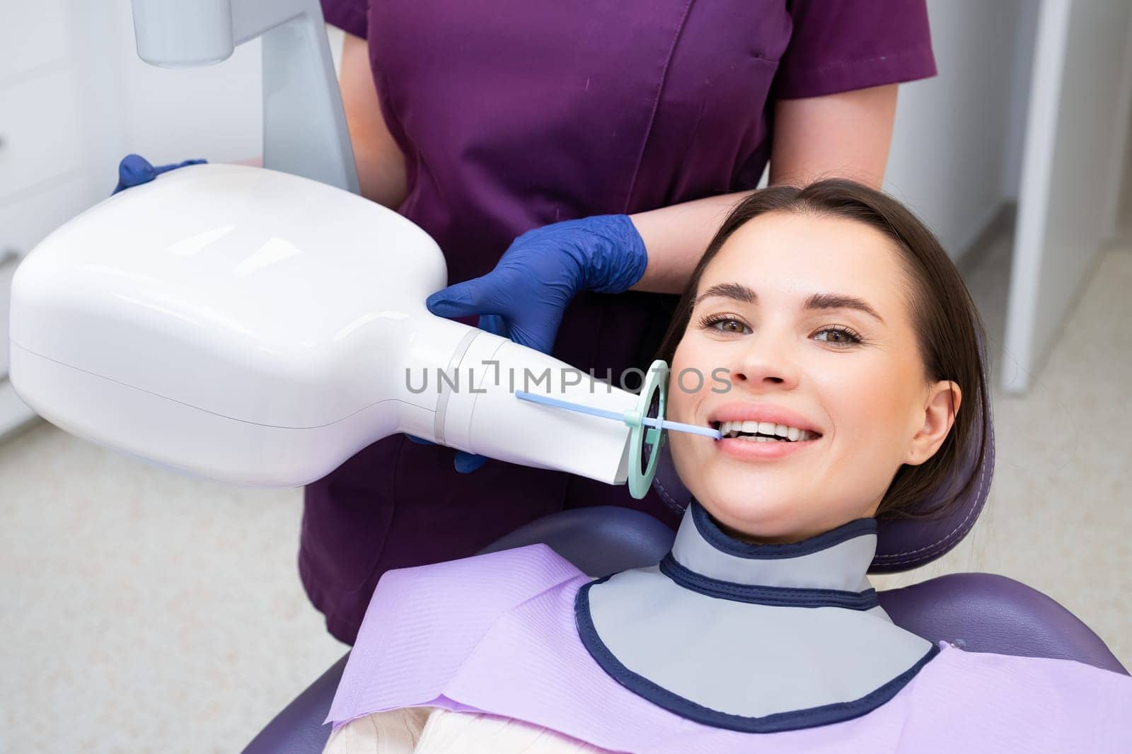 Process of preparation of patient before dental X-ray procedure. Woman instructs patient on how to tilt head before dental X-ray procedure