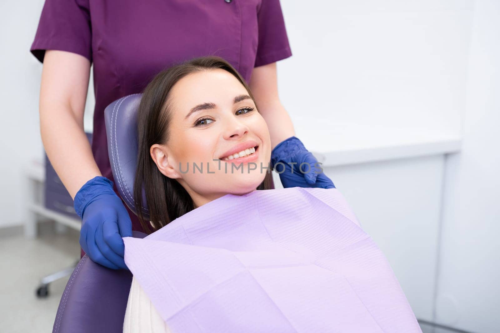 Smiling beautiful patient before treatment in a dental office